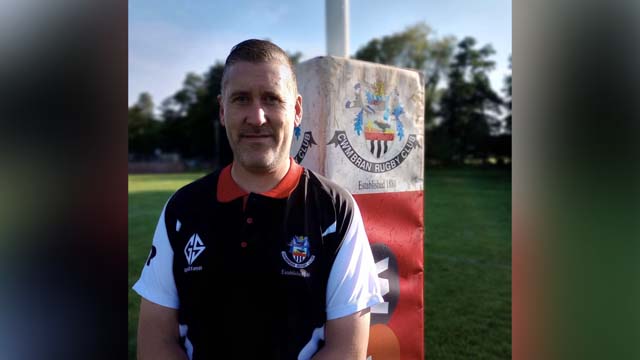 a man by a set of rugby posts