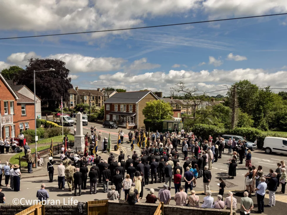 a large group of people in front of a war memorial