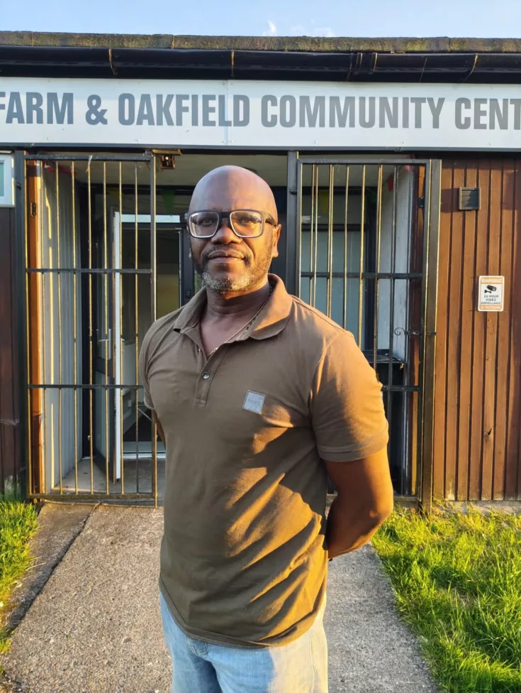 a man stood by the entrance to a community hall