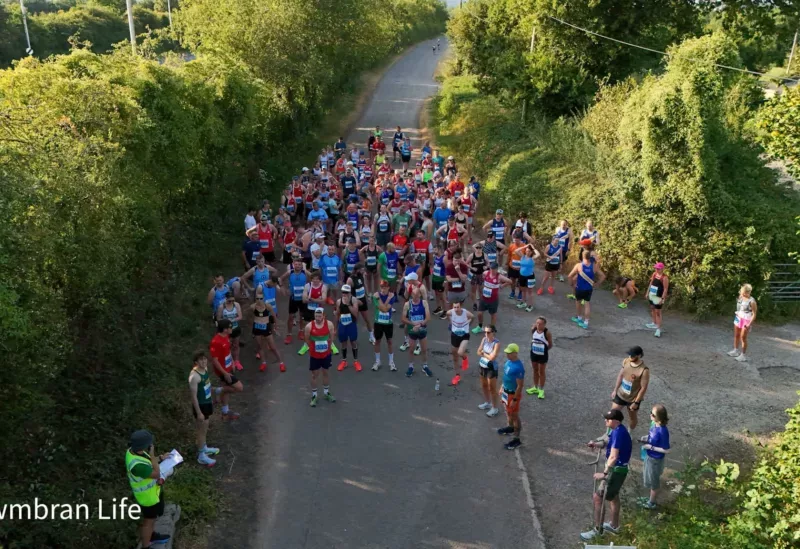 a group of runners in a country lane prepare to start a race