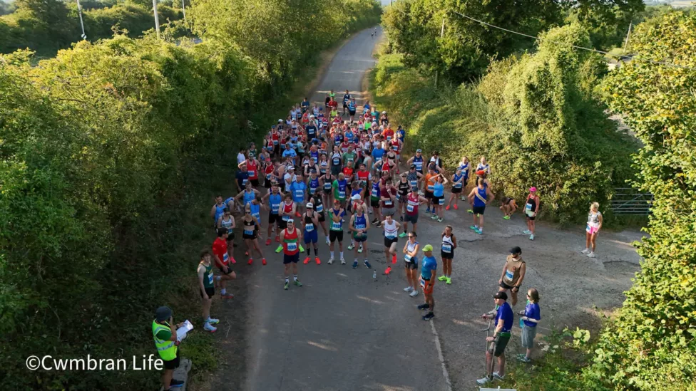 a group of runners in a country lane prepare to start a race