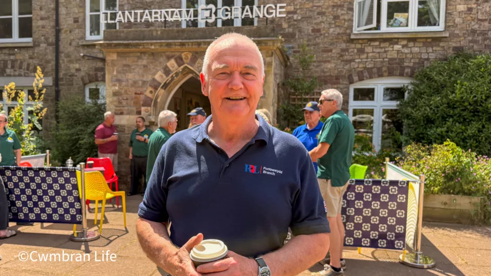 a man stood outside a building with aLlantarnam Grange sign on it