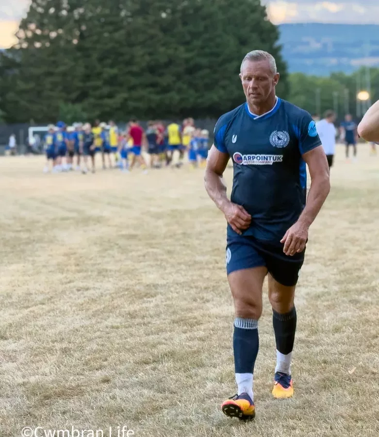 a footballer walks off a pitch