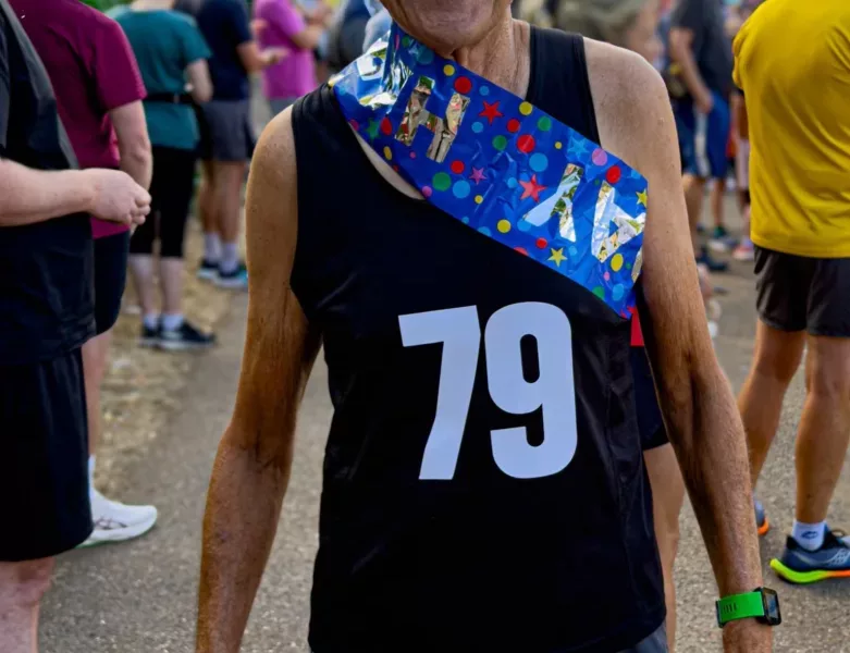 A man in running shorts and a vest with 79 on it