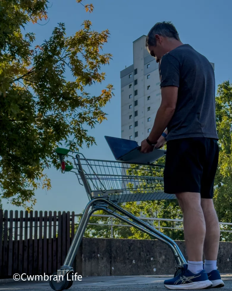 a man stood by a shopping trolley