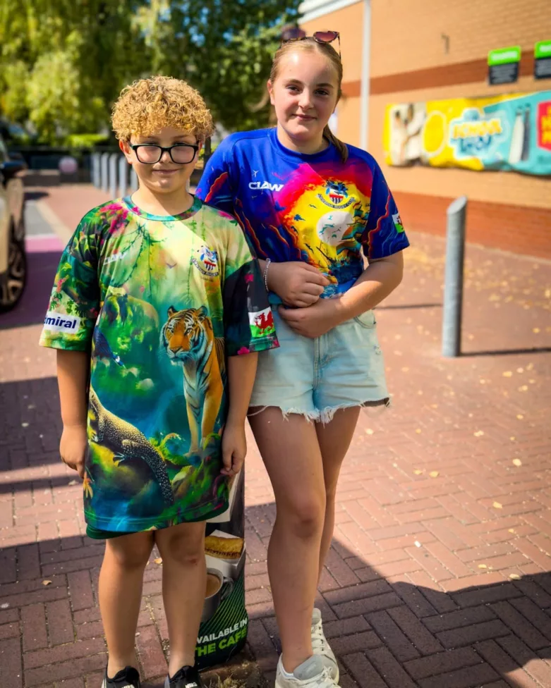 a brother and sister, aged 8 and 13, stood next to each other