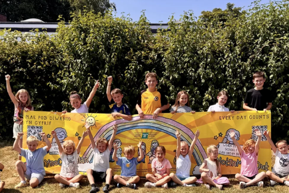 a group of children cheer and clap in a garden