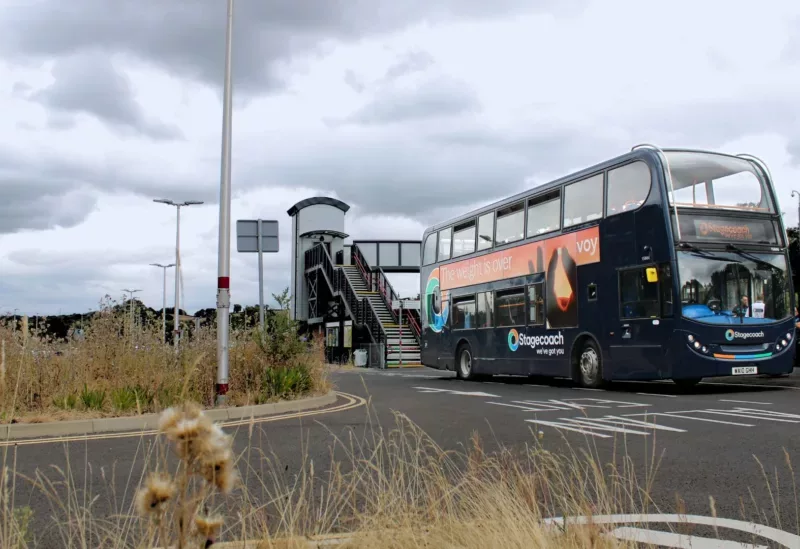 a double decker bus parked outside a train station