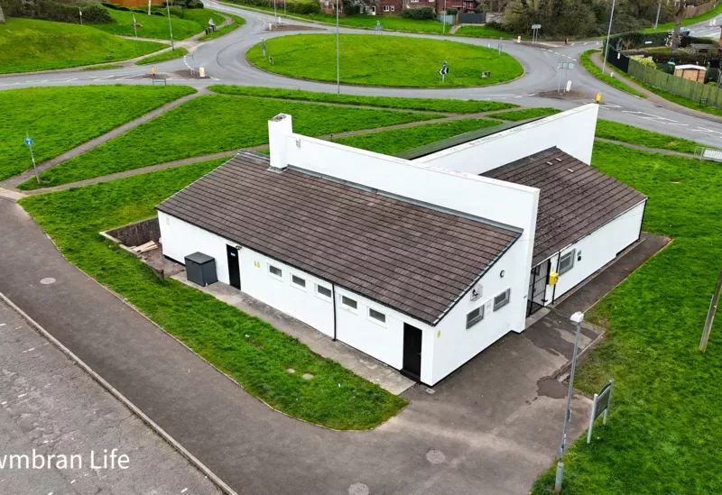 a drone photo of a community hall and car park