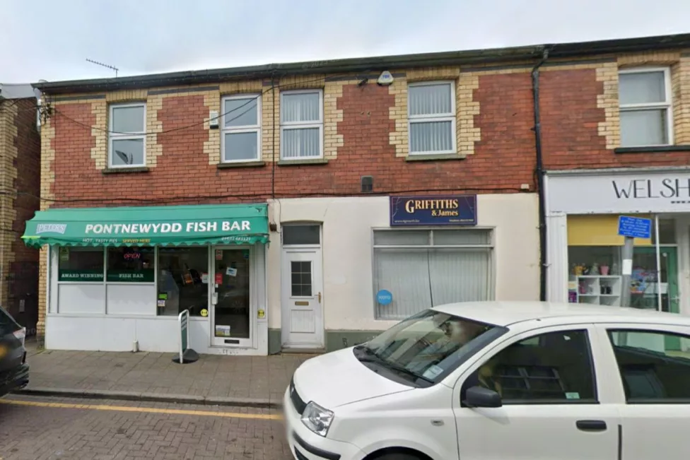 a chip shop with a car parked outside