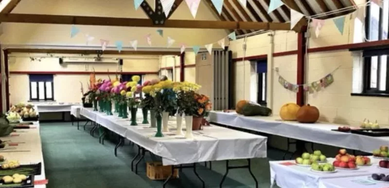 a room with a table with flowers and vegetables laid out on it