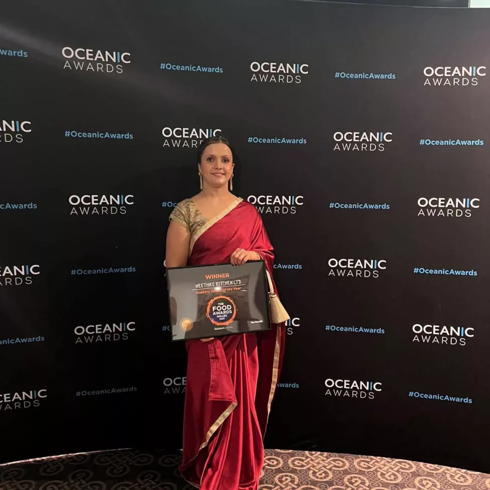a woman holding a certificate for an award